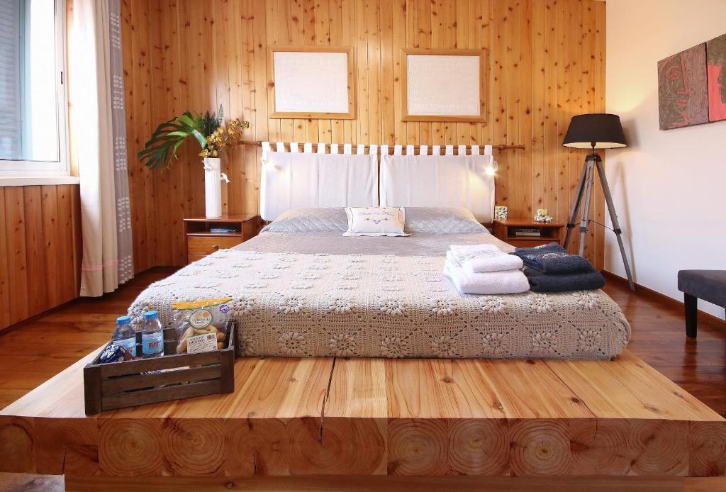 大里贝拉弗洛尔之家旅馆的一间卧室配有一张带木墙的大床