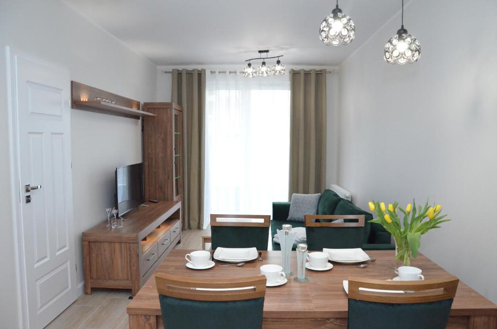 科沃布热格Apartament Luna Baltic Marina Residence的客厅配有桌椅和电视