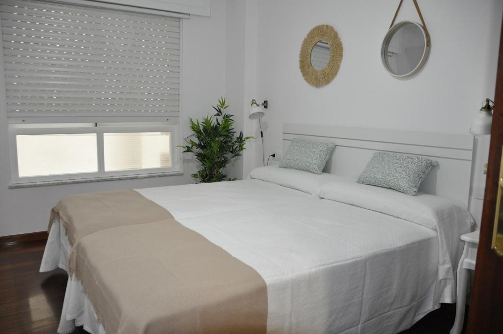 米拉多罗Alojamiento Santa Maria II的白色的卧室设有一张大床和一个窗户