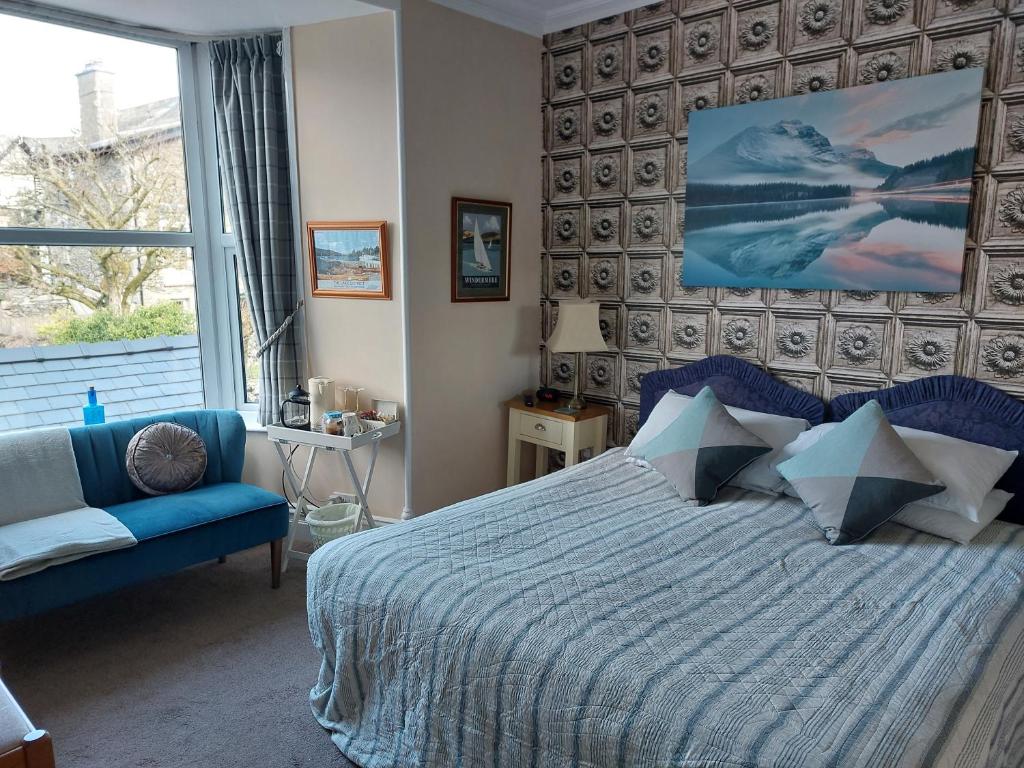 温德米尔Invergarry Room Only Guest House For Adults的一间卧室配有蓝色的床和蓝色的沙发