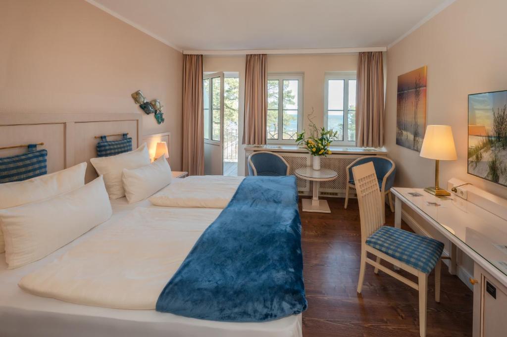 奥斯特西巴德钦诺维茨Vineta Strandhotels的酒店客房配有两张床和一张书桌