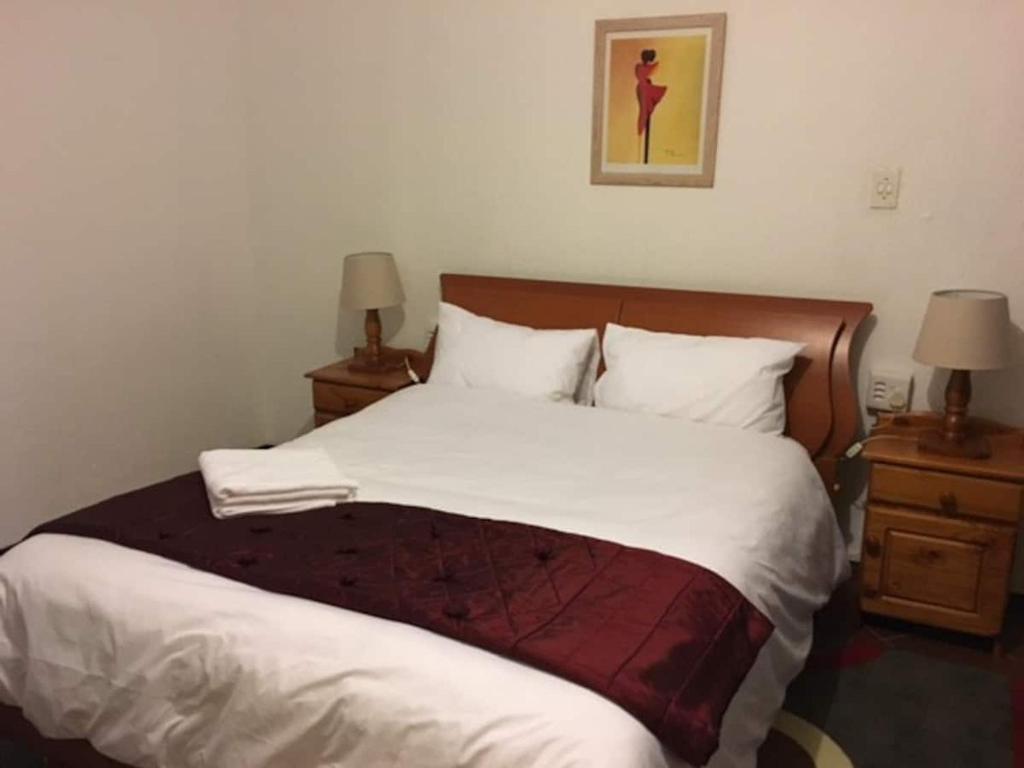 SandtonPrivate and cozy的一间卧室配有一张带2个床头柜的大床