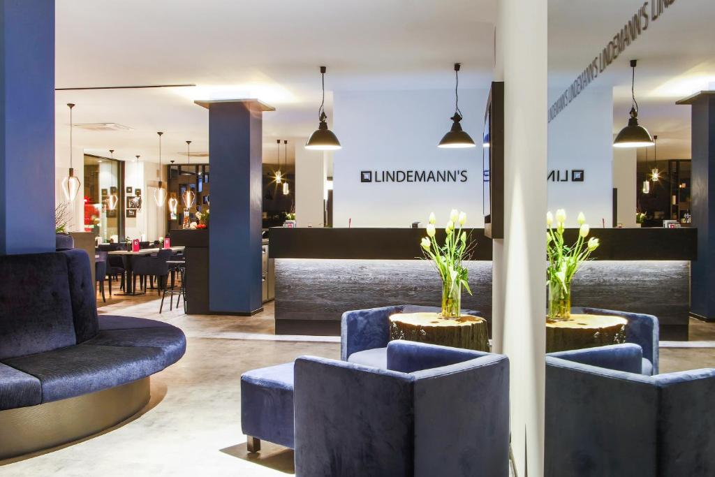 柏林林德曼酒店的一间商店的大堂,里面摆放着蓝色的椅子和桌子