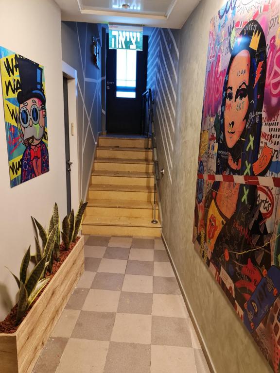 耶路撒冷SPACE ART BOUTIQUE Downtown的走廊上设有楼梯,墙上挂有绘画作品