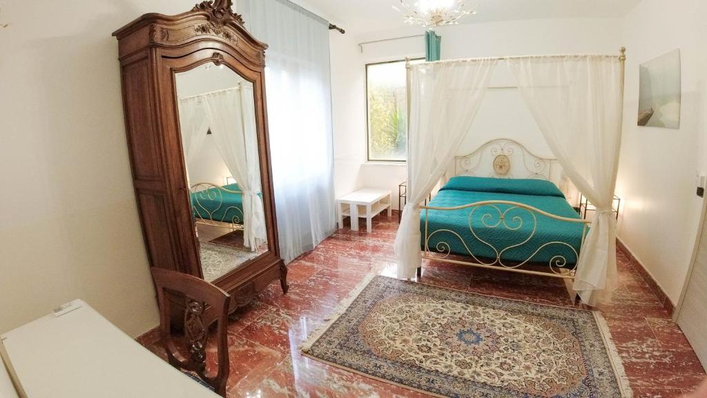 恩纳Il Piccolo Hotel的一间卧室配有一张床和镜子