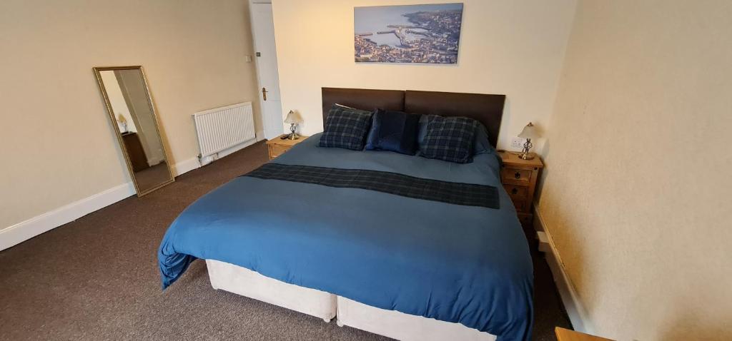 威克Harbour bridge, Camps bar的一间卧室配有一张大床,提供蓝色的床单和枕头