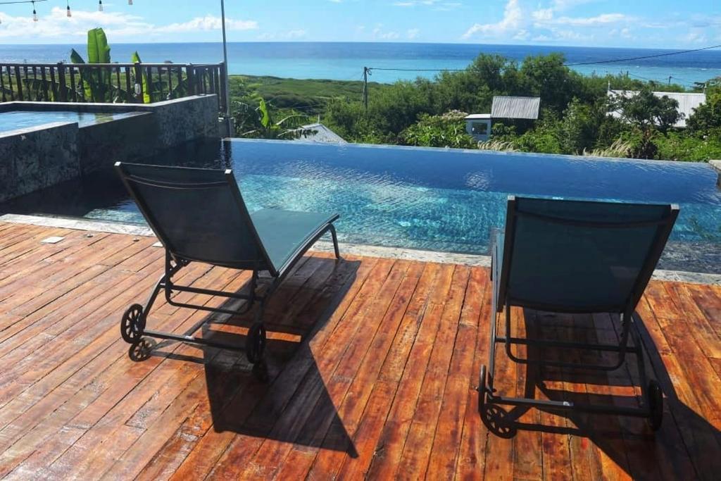 Rodrigues Island弗欧萨法特山林小屋的游泳池旁的甲板上摆放着两把椅子