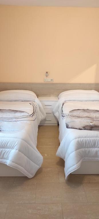 瑟森纳诺沃San Marcos的两张睡床彼此相邻,位于一个房间里