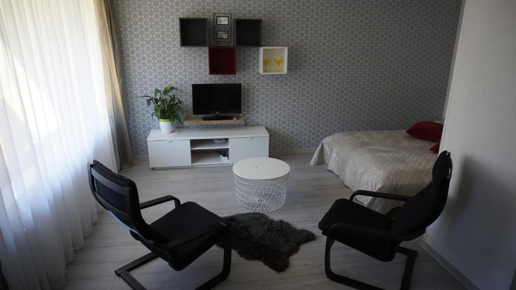 利耶帕亚LEA Apartments的一间卧室配有两把椅子、一张床和一张书桌