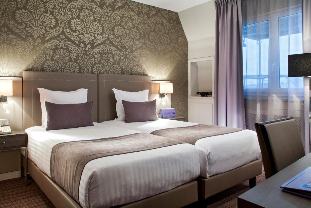 巴黎TRYP巴黎布兰驰枫丹酒店的一间设有大床和窗户的酒店客房