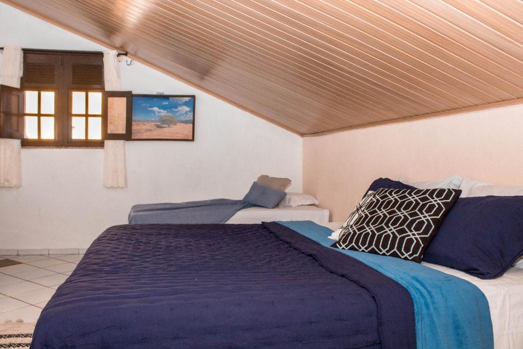 瓜拉米兰加Pousada Cogumelos的一间卧室设有一张大床和一个窗户。