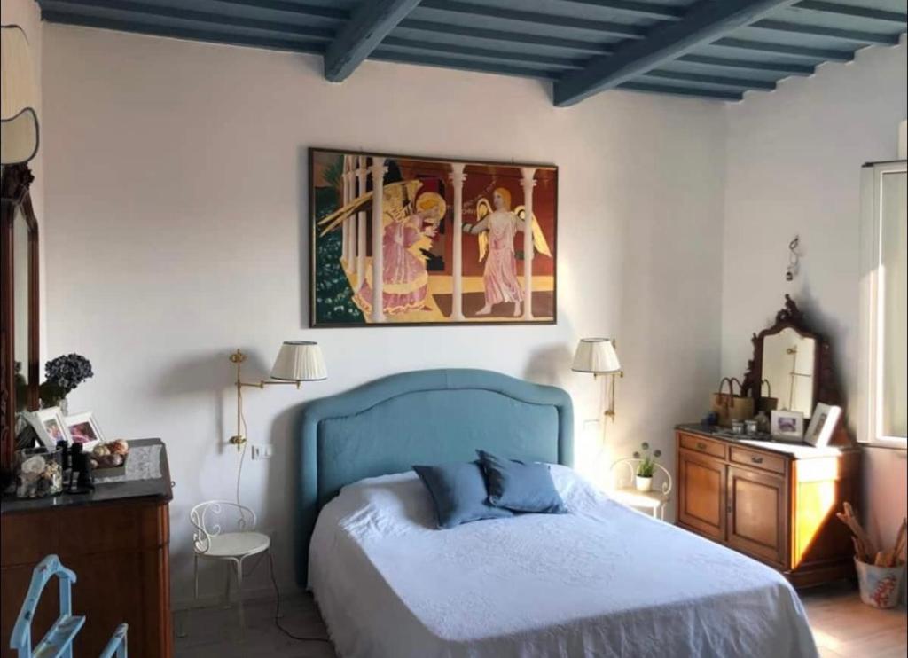 皮昂比诺La Casa di Nemo的卧室配有蓝色的床和墙上的绘画作品