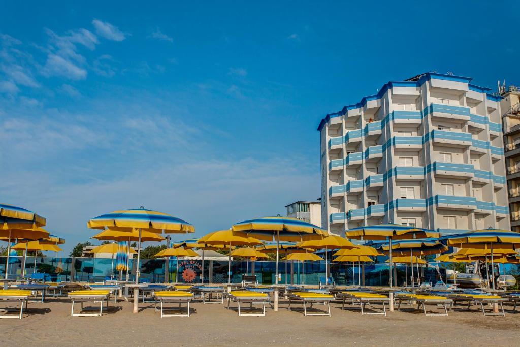 丽都迪萨维奥阿夏戈海滩酒店的一个带椅子和遮阳伞的海滩和一座建筑