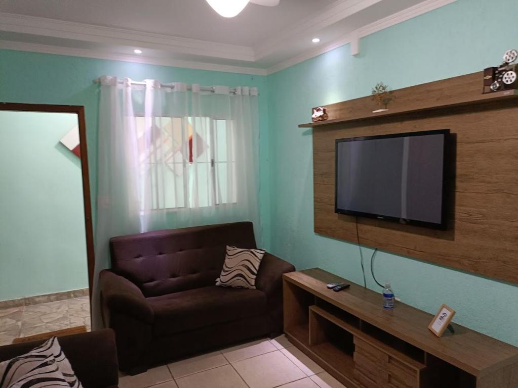 瓜鲁柳斯10 MIN AEROPORTO GUARULHOS的带沙发和平面电视的客厅