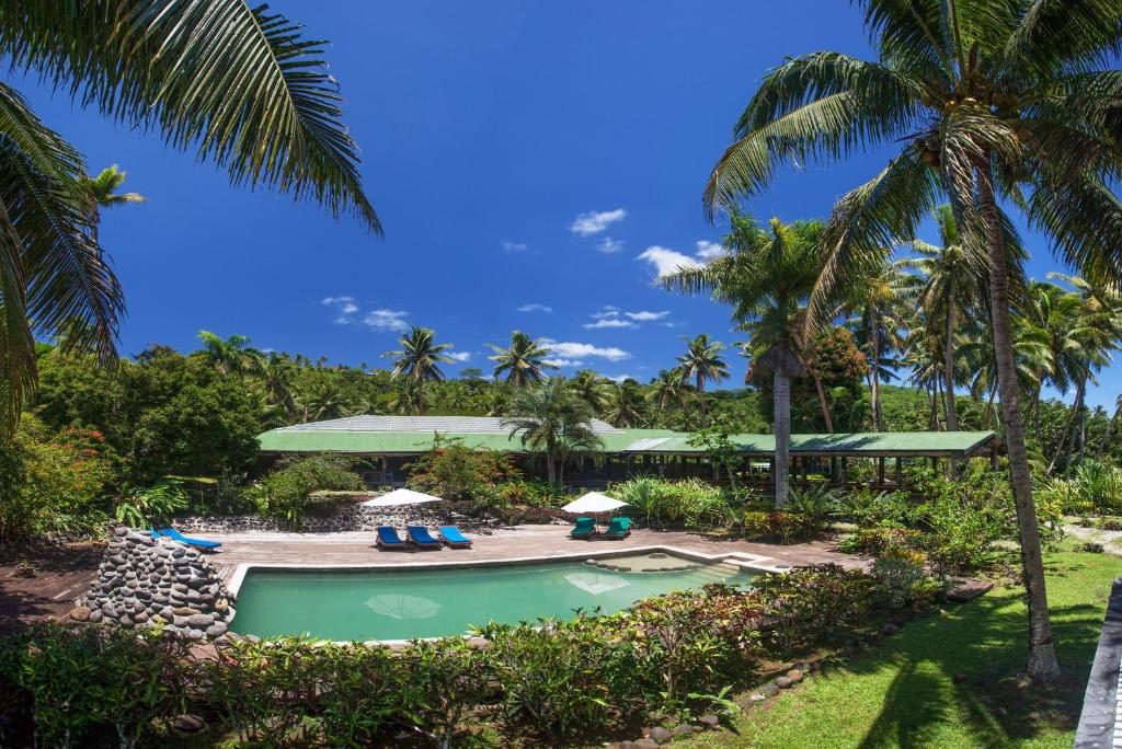 马太图武努努潜水旅馆的一个带椅子的游泳池,棕榈树
