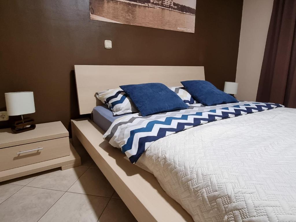 比奥格勒·纳·莫鲁M&M公寓酒店的一间卧室配有两张带蓝色枕头的床。