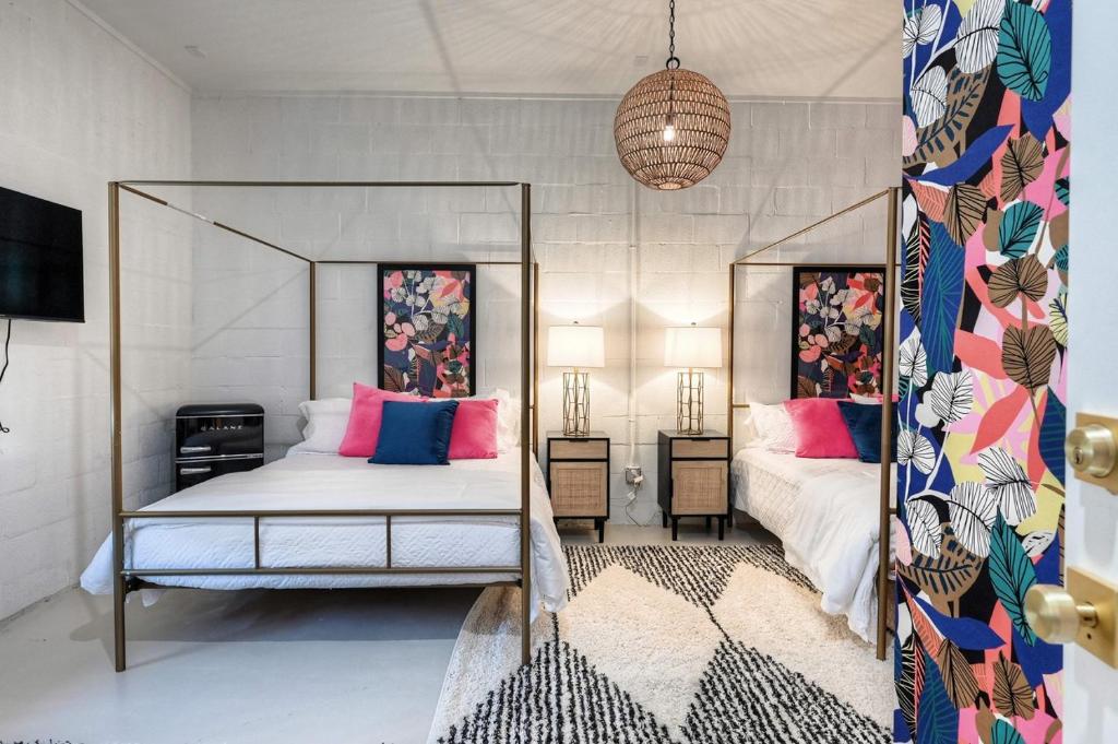 加尔维斯敦The Oleander Hotel Room 10的一间卧室配有一张带粉色和蓝色枕头的天蓬床。