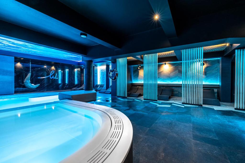 奥古斯图华沙SPA度假酒店的一座拥有蓝色灯光的室内泳池