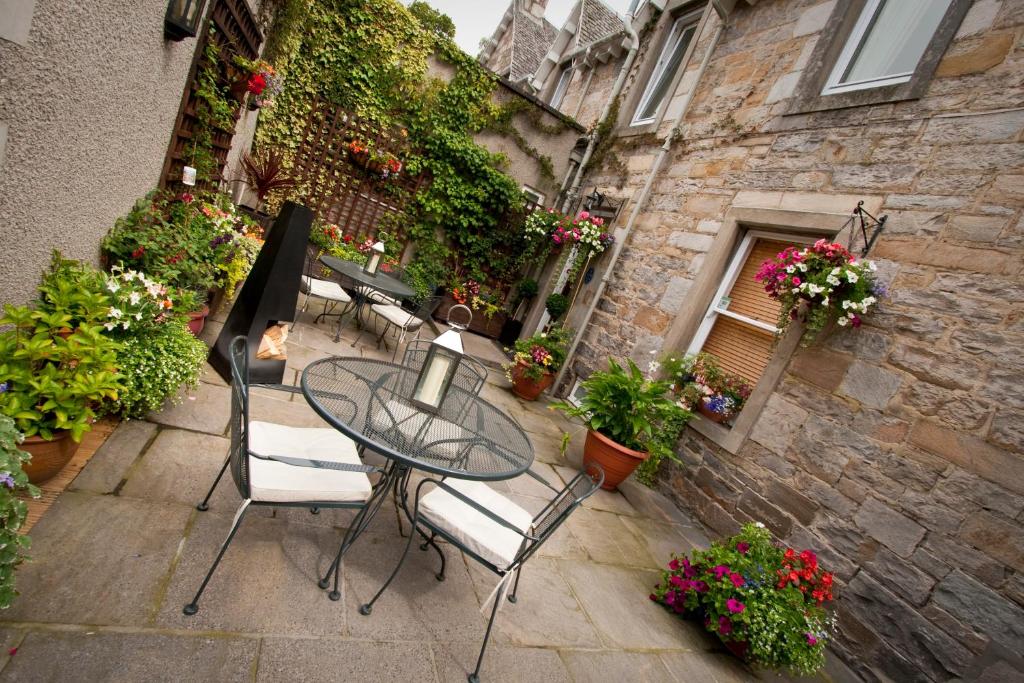 皮特洛赫里玫瑰山旅馆的庭院配有桌椅和鲜花