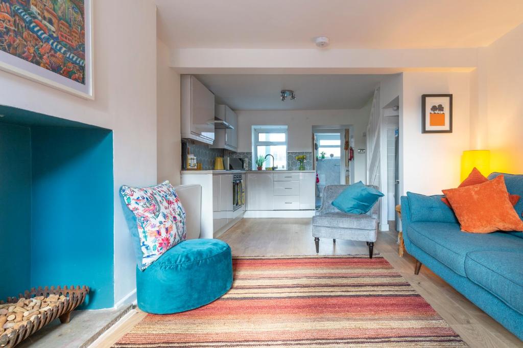 阿伯加文尼Hare Cottage的一间带蓝色沙发的客厅和一间厨房