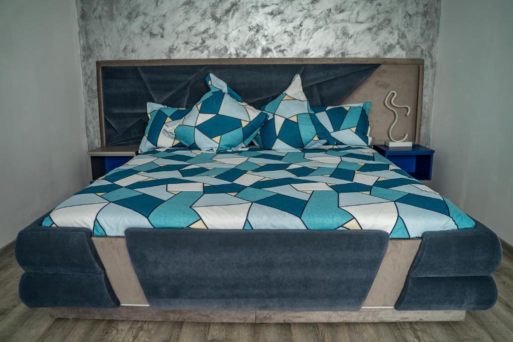 PetrilaStudio Lupul的一间卧室配有蓝色和白色的床和蓝色枕头