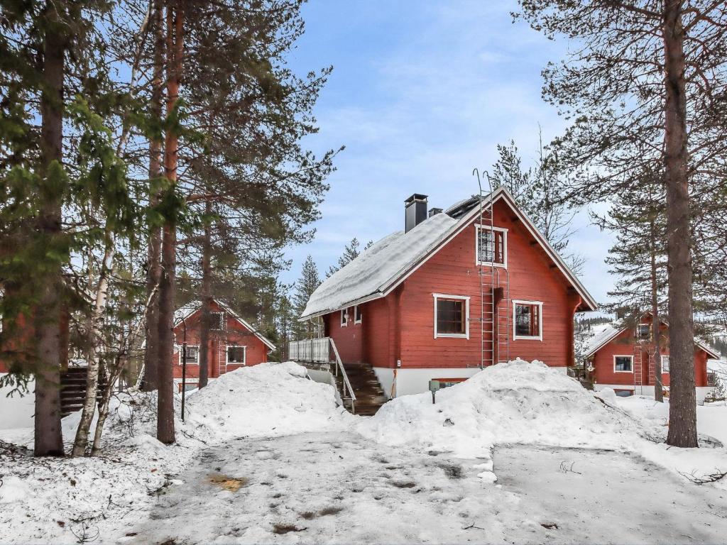 HyrynsalmiHoliday Home Alppikylä 4a paritalo by Interhome的树旁雪中的一个红色房子