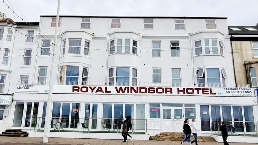 布莱克浦The Royal Windsor Hotel的一座白色的建筑,前面的人在步行