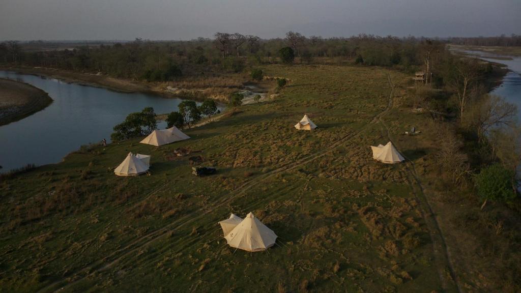 BhurkīāBurhan Wilderness Camps的河边田野上的一组帐篷