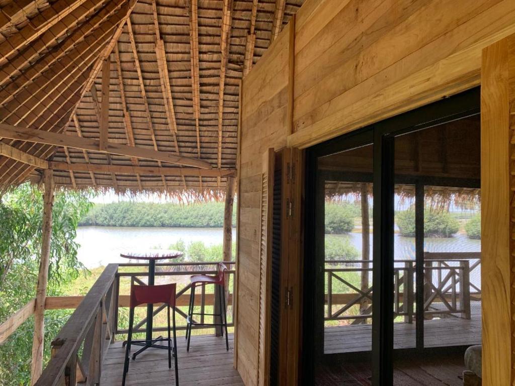 OuidahNatura luxury camp的木屋设有带桌椅的甲板