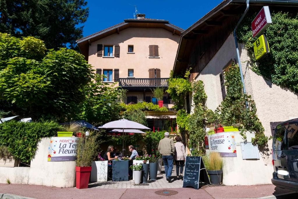 迪沃讷莱班Logis Hôtel La Terrasse Fleurie的一群人走在大楼前