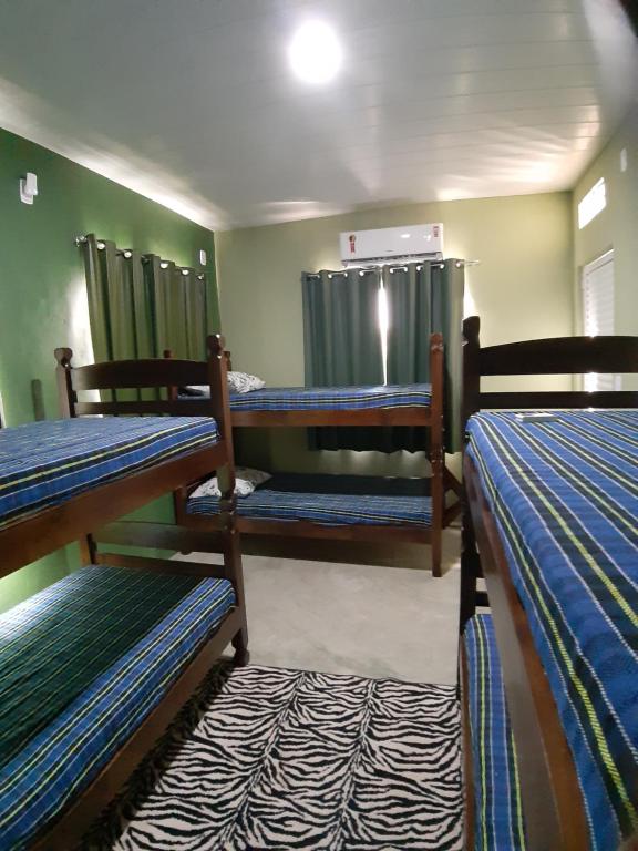 皮廷布Vida Linda Hostel的客房设有三张双层床和淋浴。