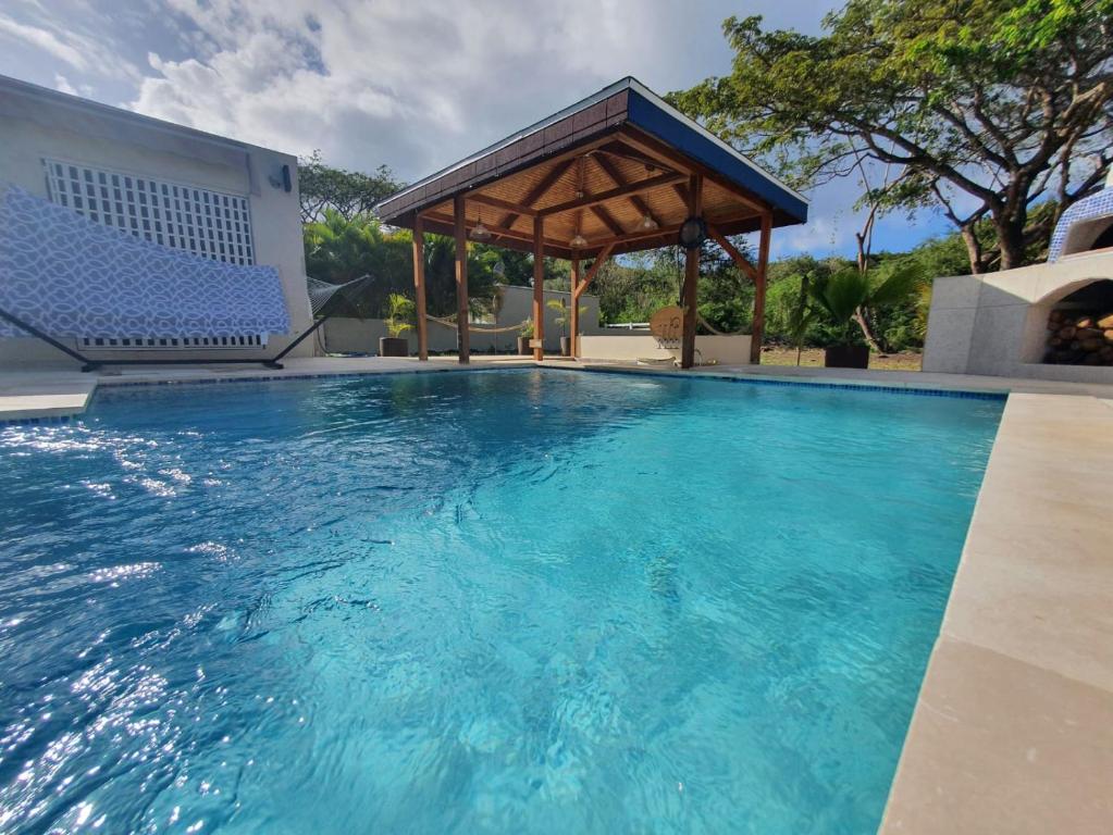 Golden GroveThe Nest Villa, A Dream Escape for the entire family的一个带凉亭和蓝色海水的游泳池