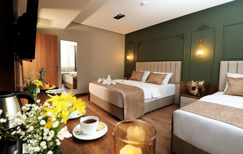 特拉布宗Bayrak Grand Hotel的酒店客房,设有两张床和一张鲜花桌。