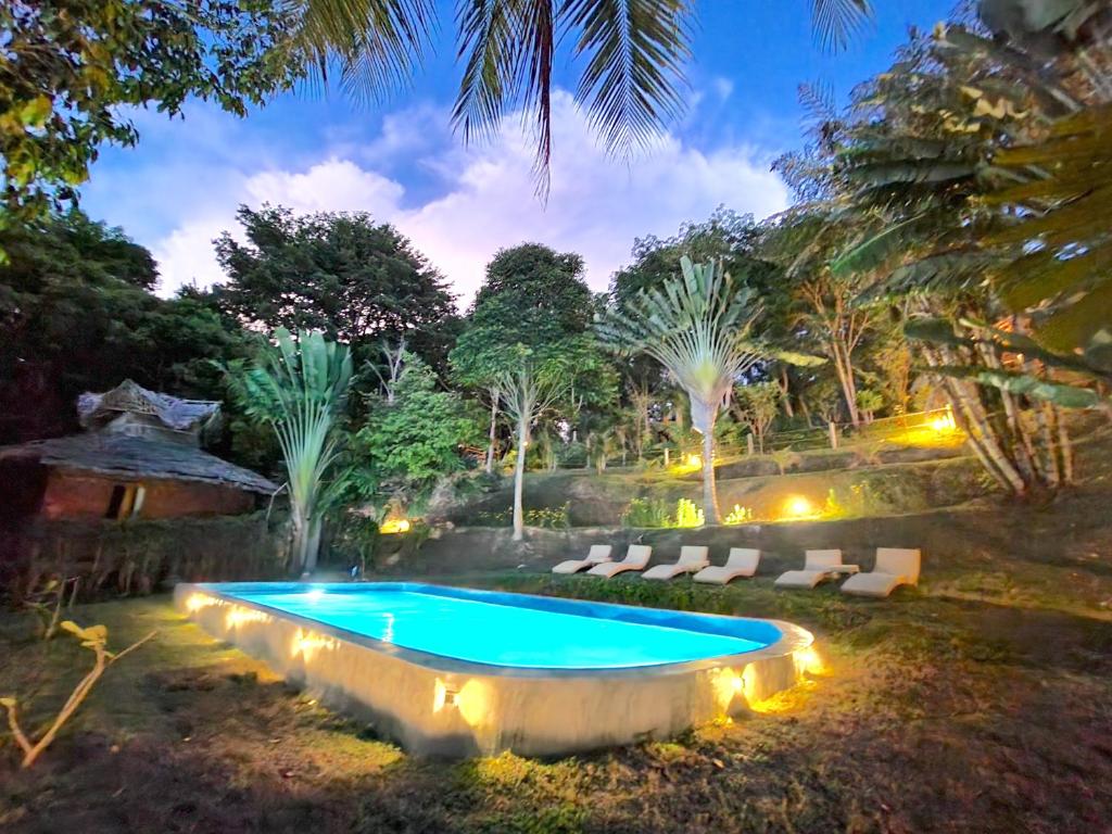 俊穆岛榕树湾别墅酒店的一个带灯光的庭院内的游泳池