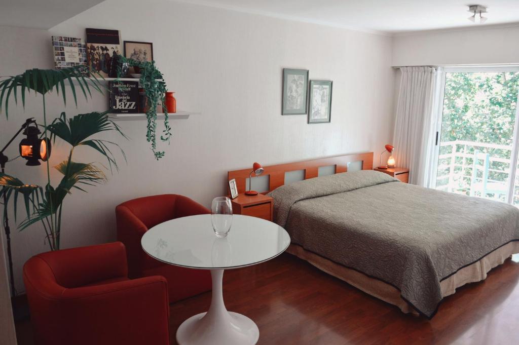 布宜诺斯艾利斯Palermo Deluxe Apartment的卧室配有1张床、1张桌子和1把椅子