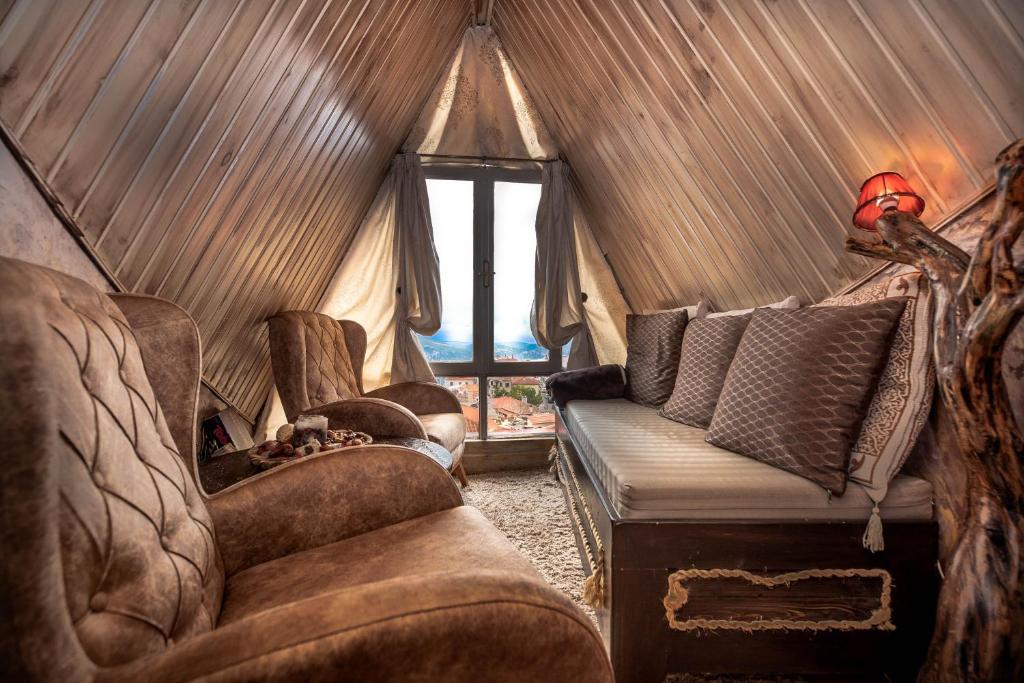 阿拉霍瓦Lykovrisi Guest House的客厅配有沙发和帐篷内的椅子