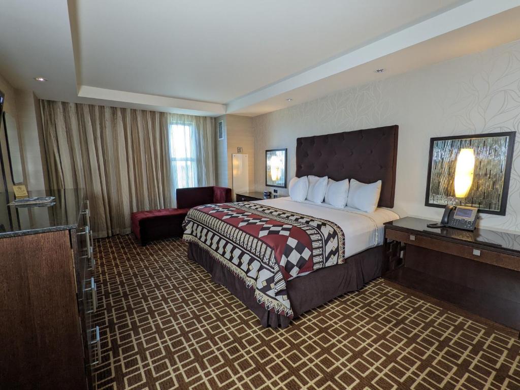 迈阿密Miccosukee Casino &amp; Resort的配有一张大床和一把椅子的酒店房间