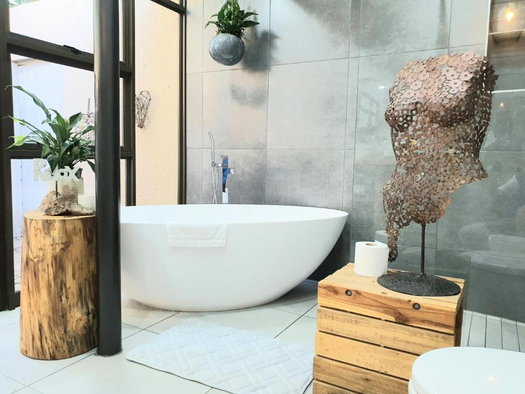 波罗瓜尼Bendor Garden Flat的带浴缸和头部雕像的浴室