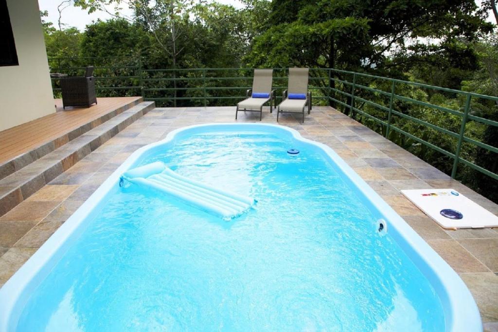 奎波斯城Tropical Paradise Villa - Beautiful Pool, Surrounded by Nature and Wildlife!的庭院内一个带两把椅子的按摩浴缸