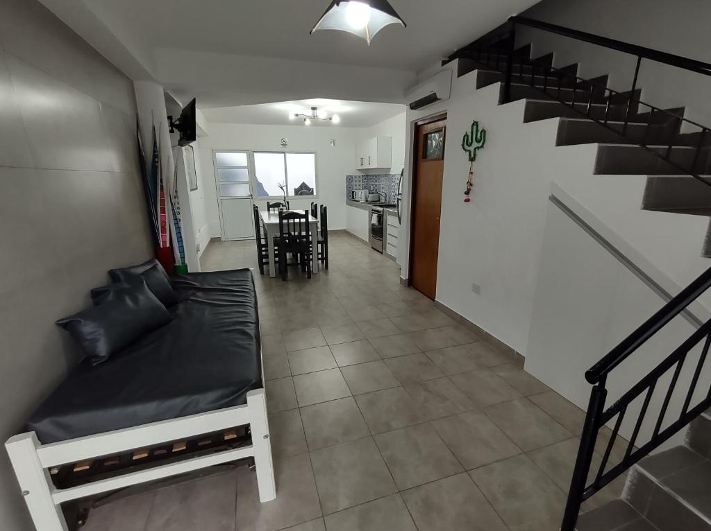 圣萨尔瓦多德朱Los Nardos Duplex的一间带床和楼梯的客厅