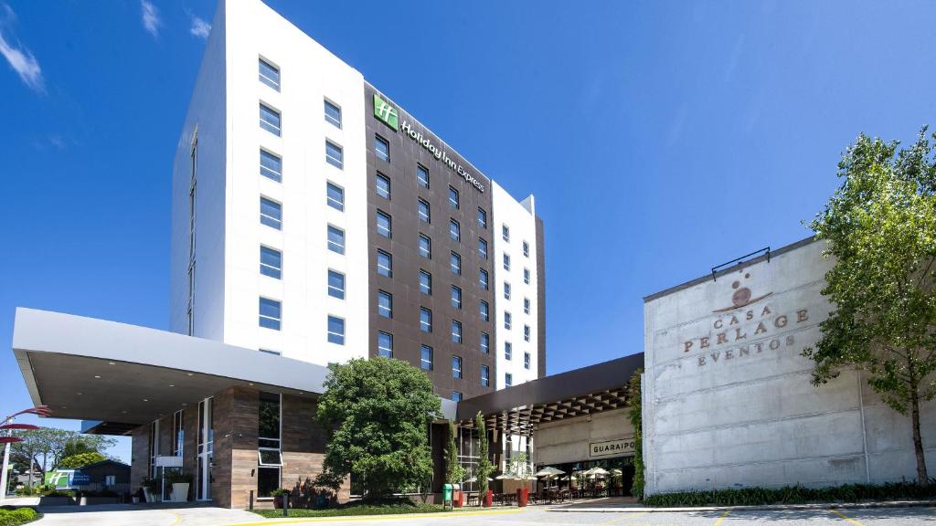 法罗皮利亚Holiday Inn Express - Farroupilha, um Hotel IHG的一座白色的大建筑,上面有标志