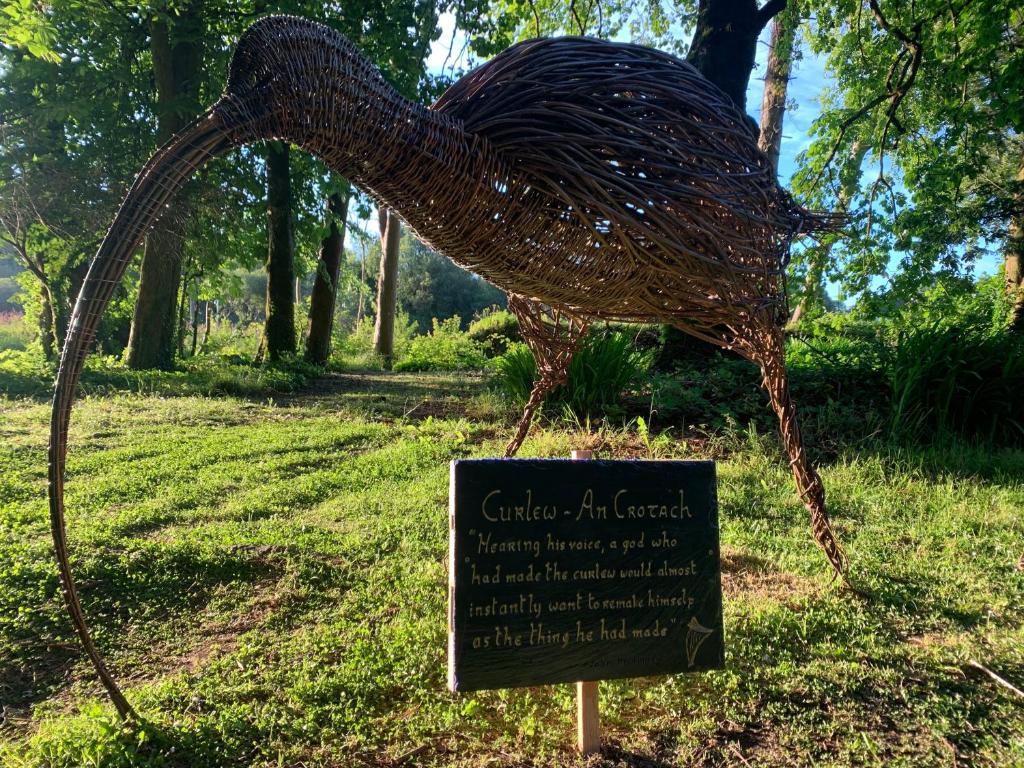 康镇Ryan's River Lodge B&B的鸟的雕像,在草上标有标志