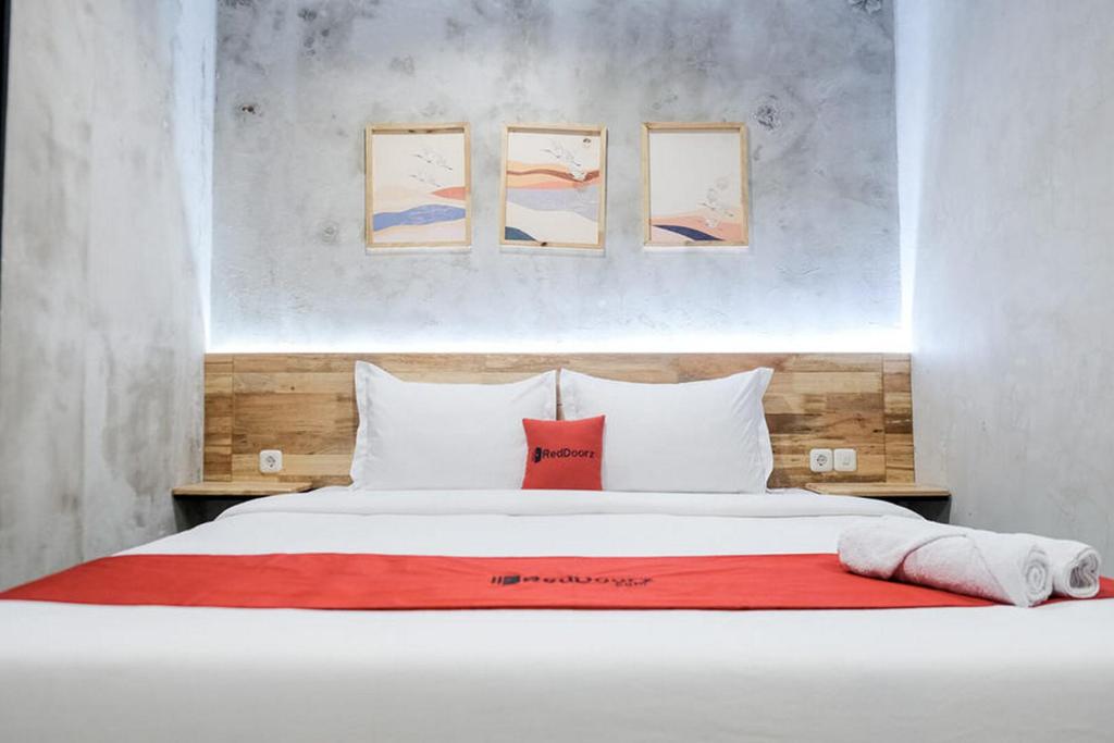 棉兰RedDoorz @ Sekip Medan的卧室配有白色的床和红色毯子