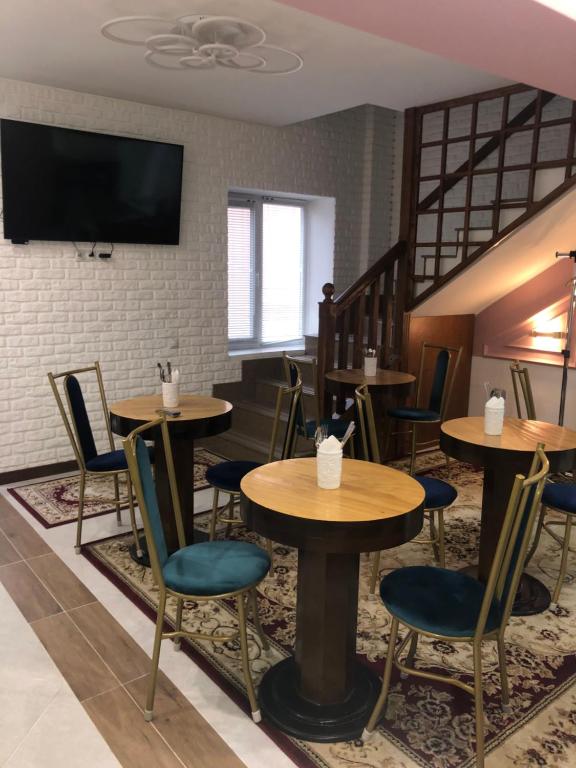 阿拉木图Samal-2 Hotel的一间带桌椅和电视的餐厅