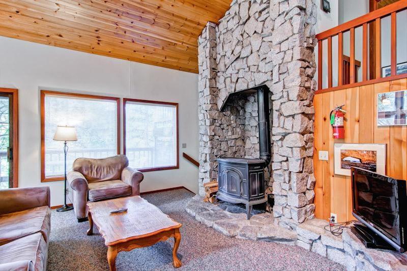 西优胜美地Sport Chalet的一间客厅,客厅内配有石头壁炉。