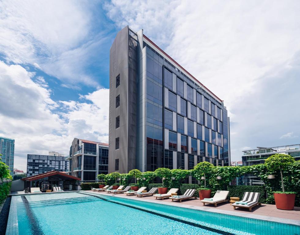 新加坡M Social Singapore的酒店拥有游泳池和躺椅