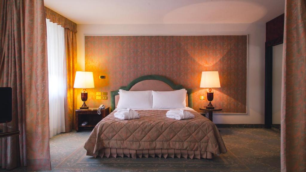 雷焦卡拉布里亚Grand Hotel Excelsior的一间卧室配有一张床,上面有两条毛巾