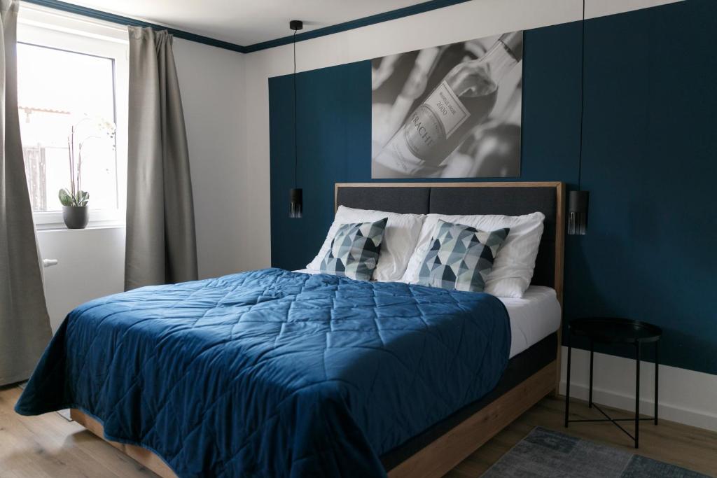 伊尔米茨KRACHER Ferienhaus Landhaus No 1的一间拥有蓝色墙壁的卧室和一张带蓝色床单的床