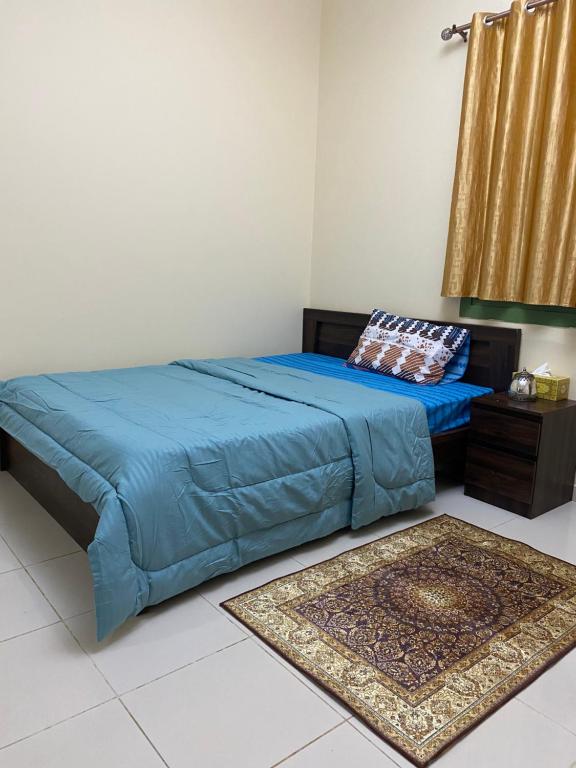 沙迦Entire Studio Flat in Sharjah.的卧室内的一张蓝色棉被