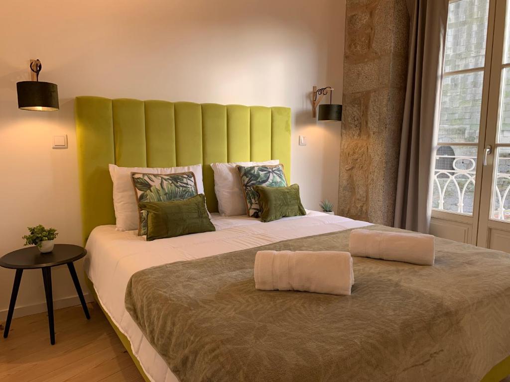 波尔图Lost Inn Porto Hostel的一张大床,在房间内有一个绿色的床头板
